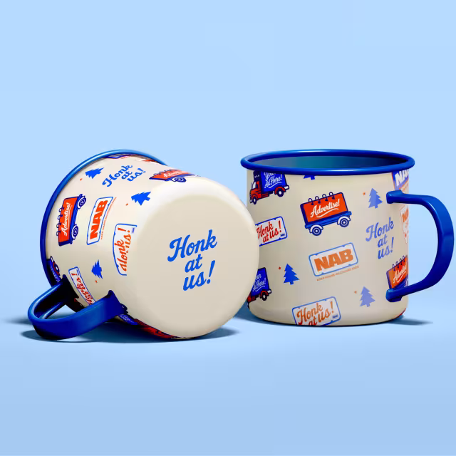 Two coffee cups with the Not Another Billboard logo.